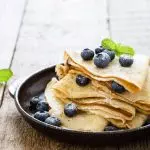 A plate of paleo crepes with blueberries